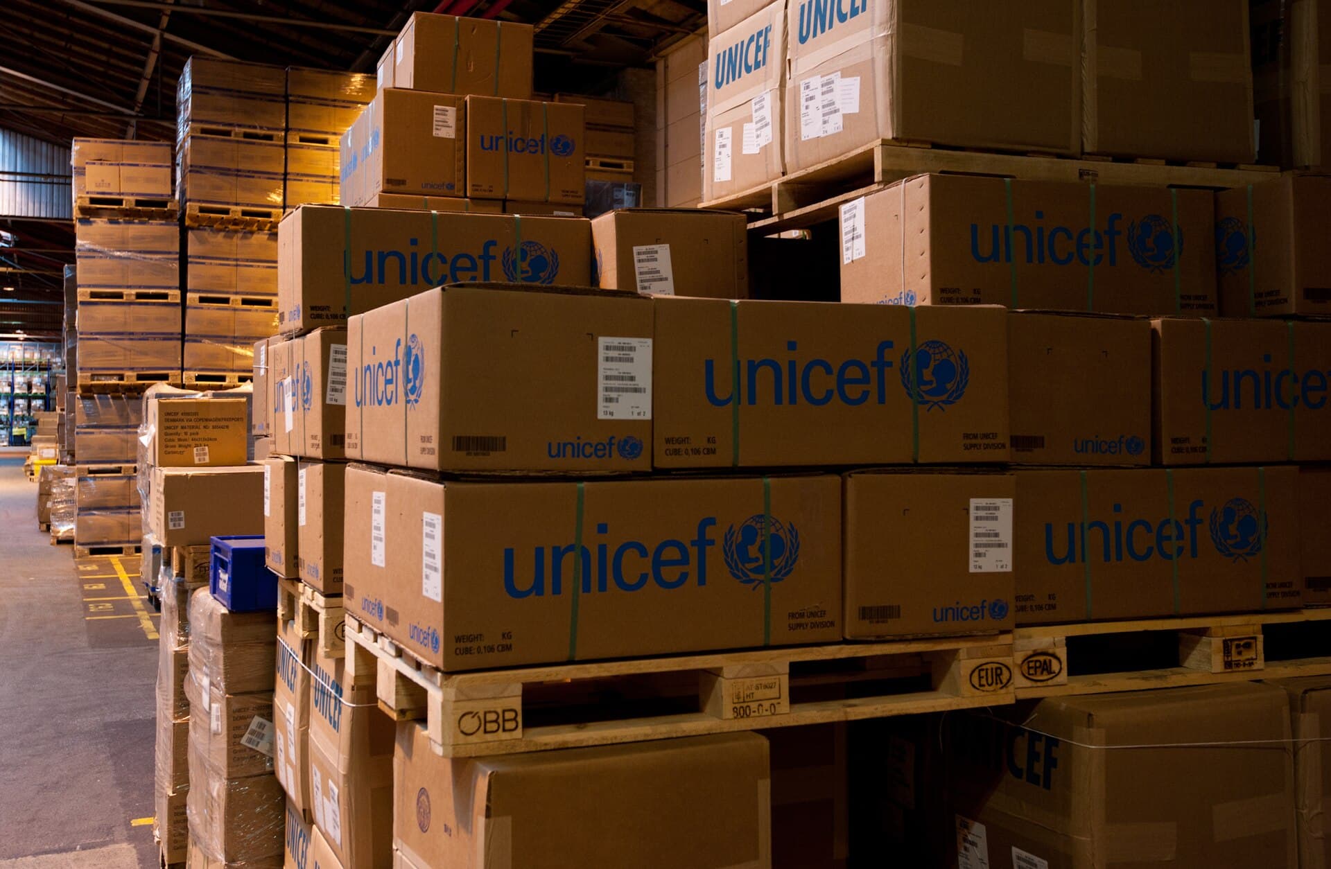Warehouse pallets stacked in a depot aisle